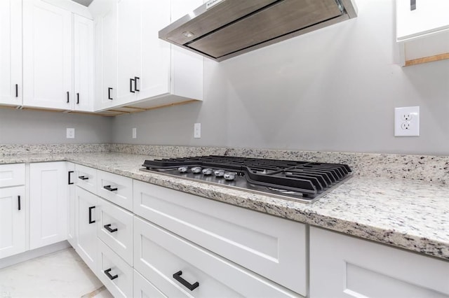 kitchen featuring light stone countertops, white cabinetry, extractor fan, and stainless steel gas stovetop