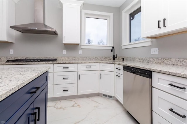 kitchen with white cabinetry, sink, wall chimney range hood, and stainless steel appliances