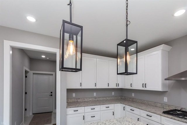 kitchen featuring pendant lighting, gas stovetop, white cabinetry, and light stone counters