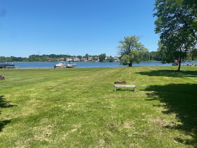 surrounding community with a yard and a water view