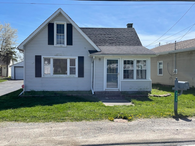 bungalow-style house with an outbuilding, a front yard, and a garage