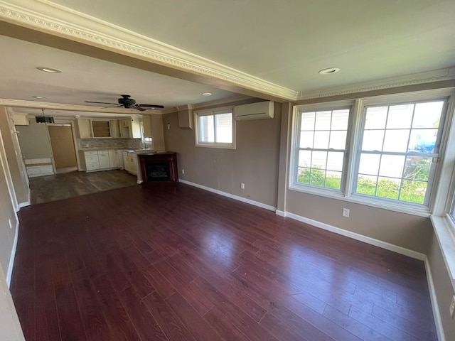 unfurnished living room with an AC wall unit, dark hardwood / wood-style floors, ceiling fan, ornamental molding, and a fireplace