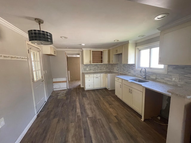 kitchen with dark wood-type flooring, sink, hanging light fixtures, light stone countertops, and ornamental molding