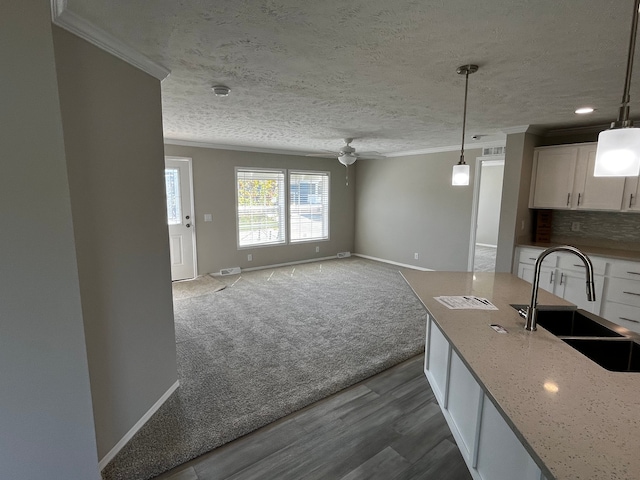 2759 Naples Ct, Lapeer, MI 48446 - kitchen with a sink, crown molding, a ceiling fan, baseboards, and white cabinetry