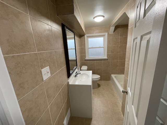 bathroom with toilet, vanity, tile patterned floors, and tile walls