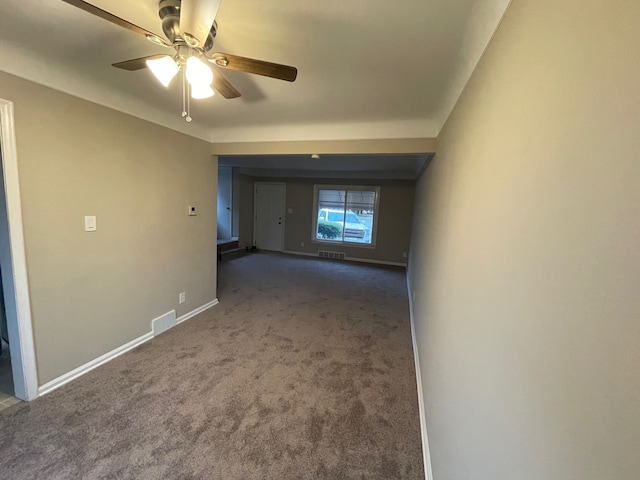 spare room with dark colored carpet and ceiling fan