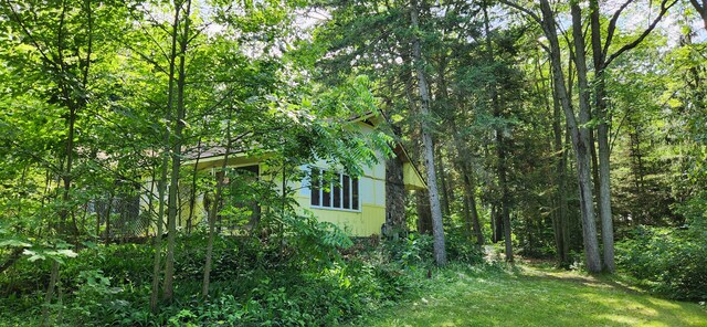 227 Joliet Ave, Houghton Lake, MI 48629 - view of side of property featuring a wooded view