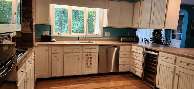 kitchen featuring light hardwood / wood-style flooring, stainless steel appliances, wine cooler, and sink