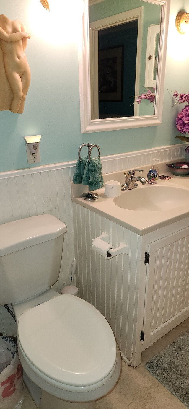 227 Joliet Ave, Houghton Lake, MI 48629 - bathroom with toilet, a wainscoted wall, and vanity