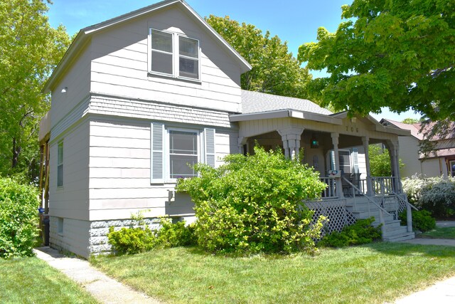 view of front of house with covered porch and a front yard