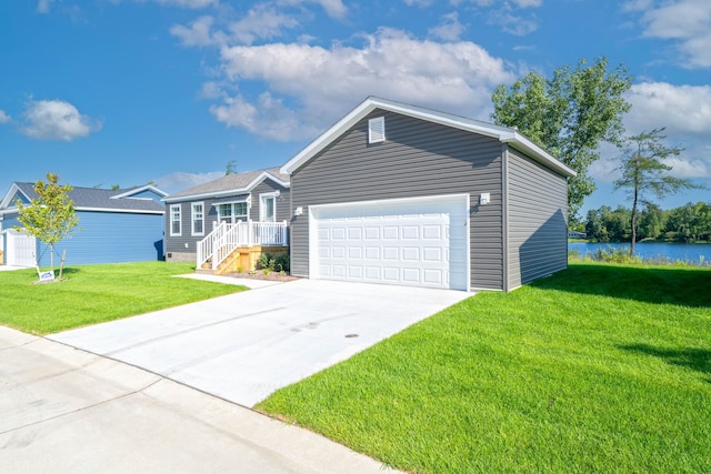 view of front of property with a front yard, a water view, and a garage