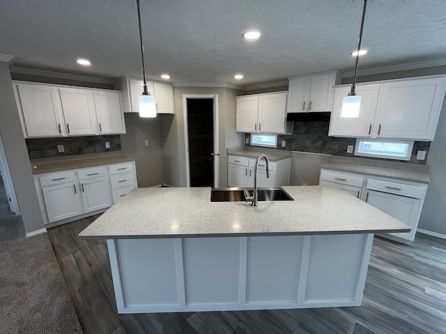 2765 Naples Ct, Lapeer, MI 48446 - kitchen featuring a sink, a kitchen island with sink, tasteful backsplash, ornamental molding, and white cabinetry