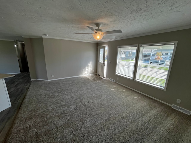 unfurnished living room featuring dark carpet, ornamental molding, and a textured ceiling