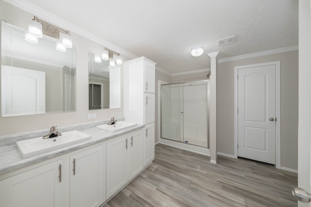 bathroom featuring crown molding, a shower with door, vanity, and wood-type flooring