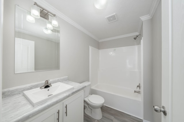 full bathroom featuring vanity, washtub / shower combination, hardwood / wood-style flooring, toilet, and ornamental molding