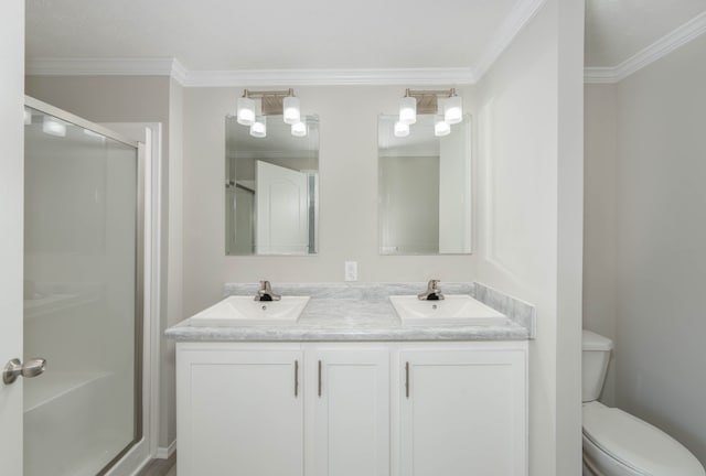 bathroom with vanity, toilet, a shower with door, and ornamental molding