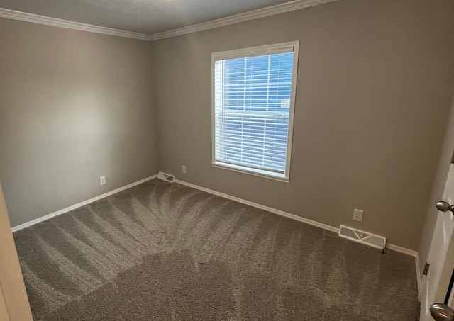 empty room featuring dark colored carpet and crown molding