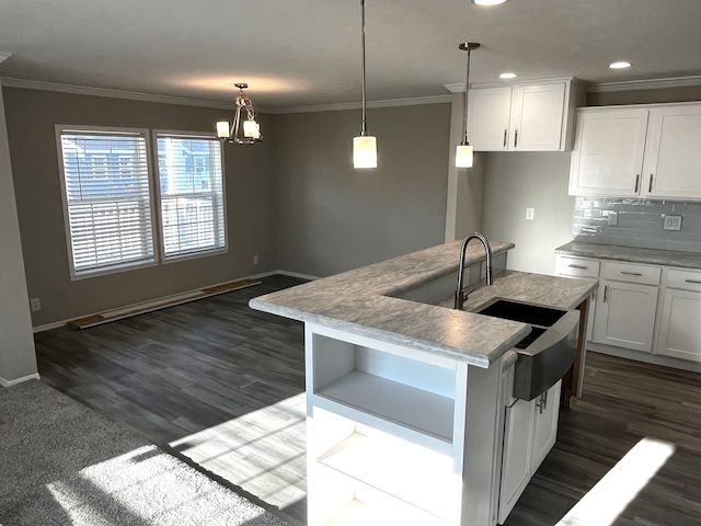 kitchen with a notable chandelier, a center island with sink, decorative light fixtures, dark hardwood / wood-style flooring, and white cabinetry