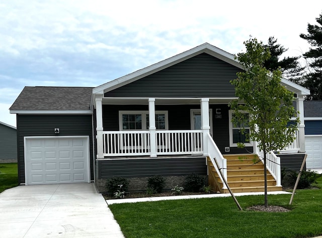 view of front of property featuring a front lawn, a porch, and a garage