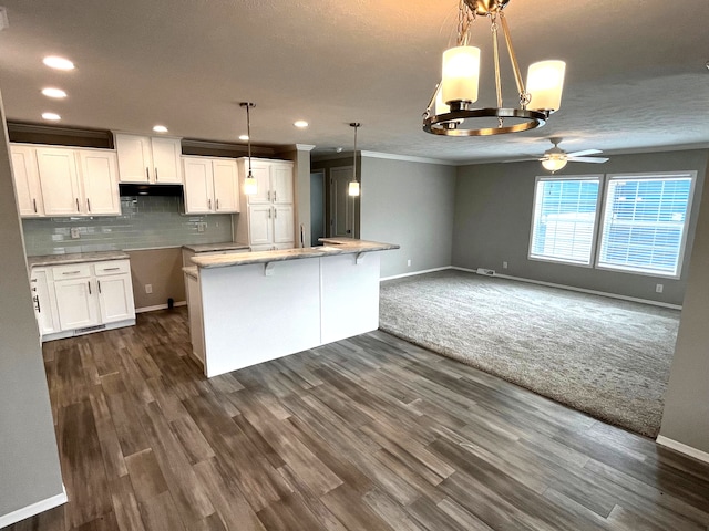 kitchen featuring dark hardwood / wood-style flooring, tasteful backsplash, ceiling fan, white cabinets, and hanging light fixtures