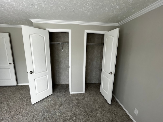 unfurnished bedroom with two closets, dark carpet, and a textured ceiling