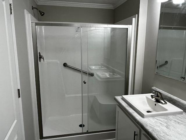 bathroom featuring vanity, a shower with door, and ornamental molding