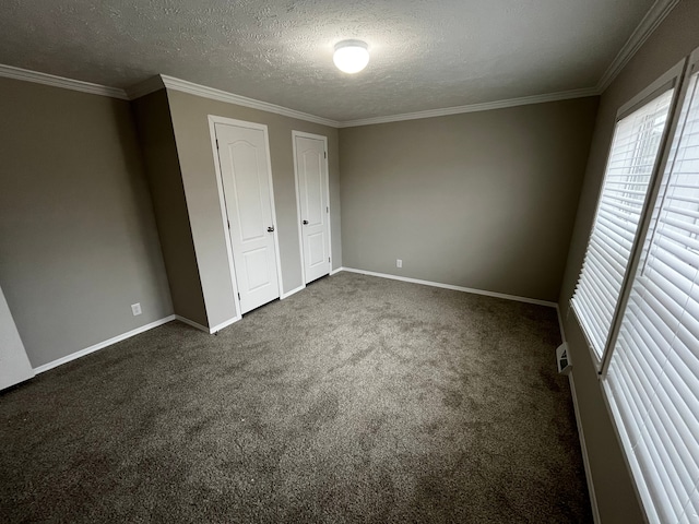 unfurnished bedroom featuring dark colored carpet, a textured ceiling, and crown molding