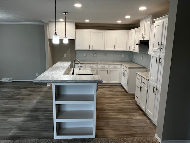 kitchen featuring a kitchen island with sink, sink, pendant lighting, dark hardwood / wood-style floors, and white cabinetry