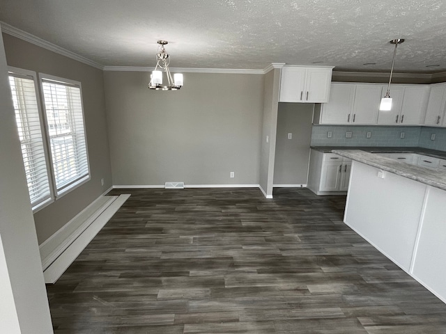 kitchen featuring white cabinets, dark hardwood / wood-style flooring, ornamental molding, and backsplash