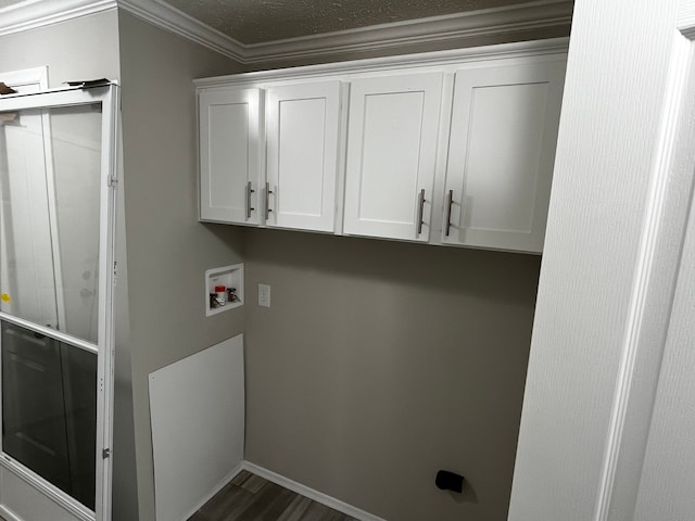 clothes washing area featuring cabinets, crown molding, washer hookup, dark hardwood / wood-style floors, and a textured ceiling