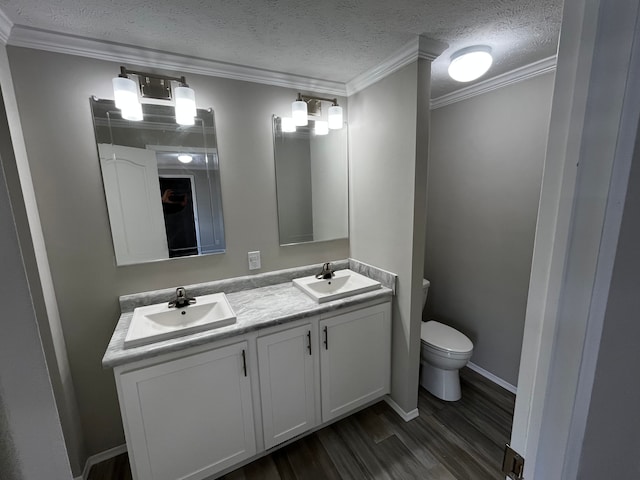 bathroom featuring vanity, a textured ceiling, crown molding, hardwood / wood-style flooring, and toilet