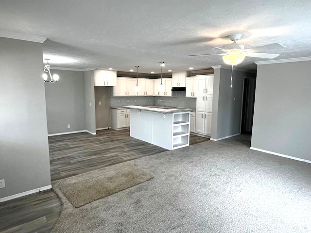 2776 Naples Ct, Lapeer, MI 48446 - kitchen with baseboards, ornamental molding, white cabinets, ceiling fan, and a kitchen island with sink