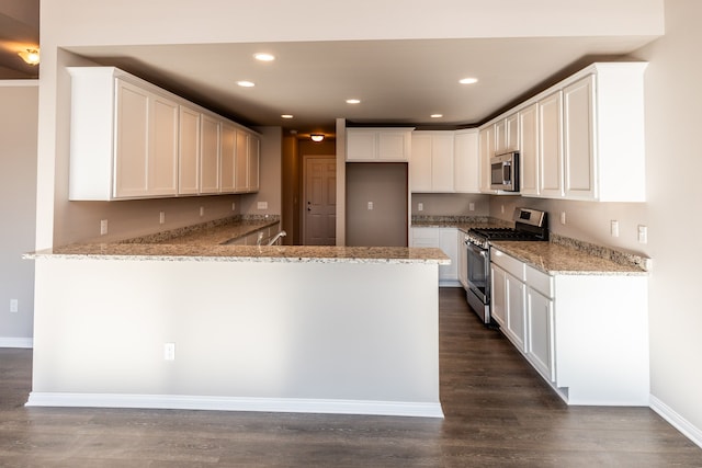 kitchen with kitchen peninsula, dark hardwood / wood-style flooring, light stone counters, white cabinetry, and stainless steel appliances