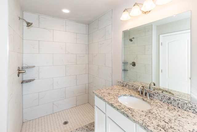 bathroom featuring tiled shower and vanity