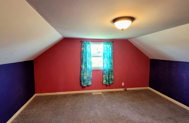 additional living space with lofted ceiling, carpet, baseboards, and visible vents