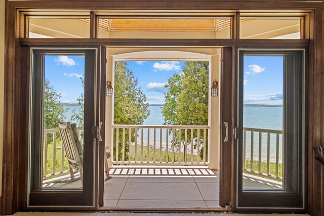 7545 Oyster Bay Dr Unit 4, Charlevoix, MI 49720 - entryway with a water view, tile patterned floors, and plenty of natural light