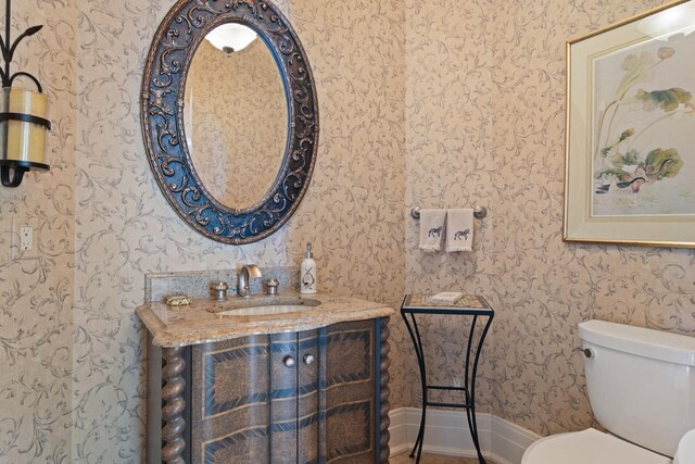 7545 Oyster Bay Dr Unit 4, Charlevoix, MI 49720 - bathroom featuring wallpapered walls, toilet, vanity, and baseboards