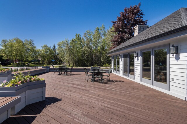 7545 Oyster Bay Dr Unit 4, Charlevoix, MI 49720 - wooden deck with outdoor dining space