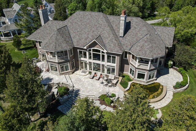 7545 Oyster Bay Dr Unit 4, Charlevoix, MI 49720 - back of house with a balcony, a chimney, and a patio