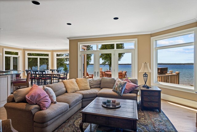 7545 Oyster Bay Dr Unit 4, Charlevoix, MI 49720 - living room with ornamental molding, a water view, dark wood-style floors, plenty of natural light, and recessed lighting
