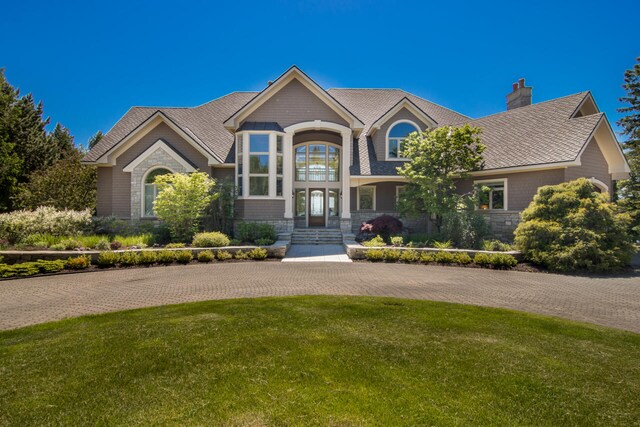 7545 Oyster Bay Dr Unit 4, Charlevoix, MI 49720 - view of front of property with a chimney, stone siding, and a front yard