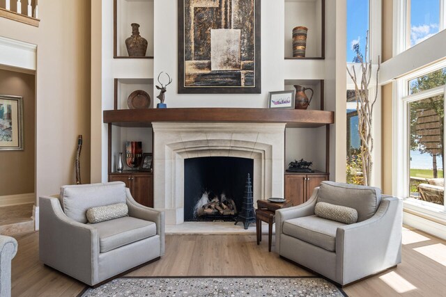 7545 Oyster Bay Dr Unit 4, Charlevoix, MI 49720 - living area with wood finished floors and a fireplace with raised hearth