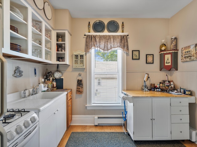 kitchen with white range, light wood-type flooring, tasteful backsplash, white cabinetry, and a baseboard radiator