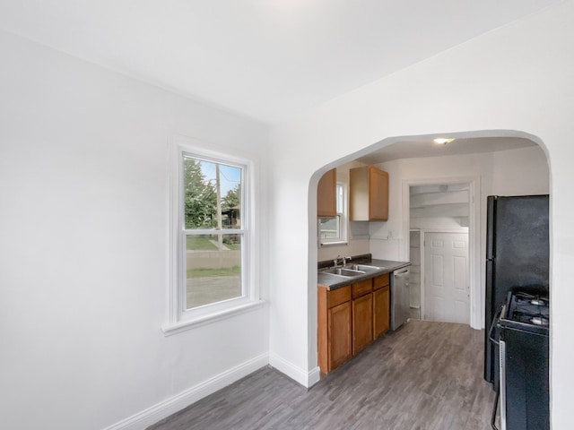 30430 Utica Rd, Roseville, MI 48066 - kitchen featuring appliances with stainless steel finishes, brown cabinetry, a sink, arched walkways, and light wood-style floors