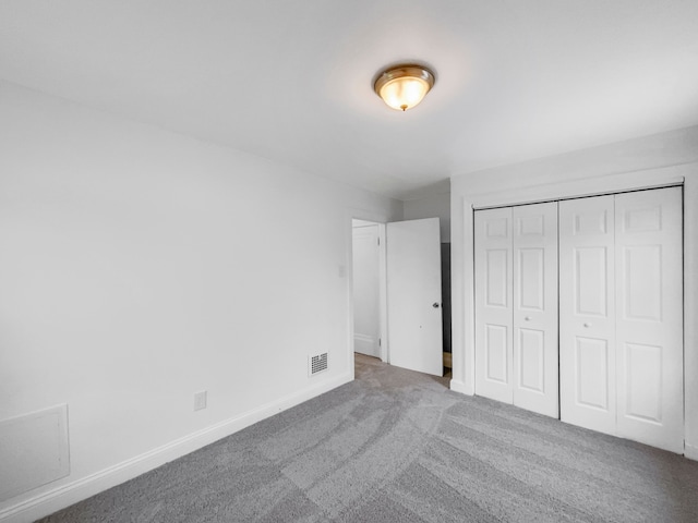 unfurnished bedroom with light carpet and a closet