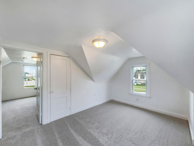 bonus room with light carpet and lofted ceiling