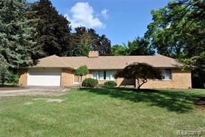 ranch-style house with a garage and a front lawn