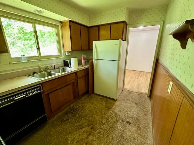 kitchen featuring sink, white fridge, wood-type flooring, and black dishwasher