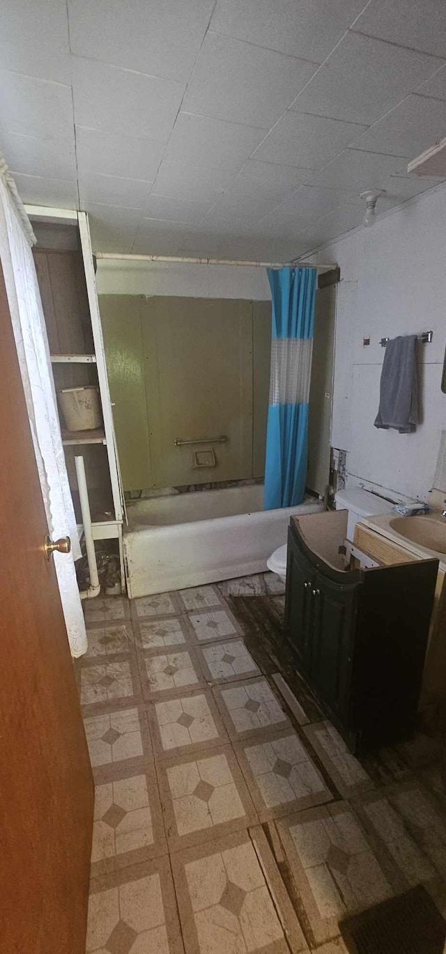 bathroom featuring a paneled ceiling, shower / bath combo with shower curtain, and vanity