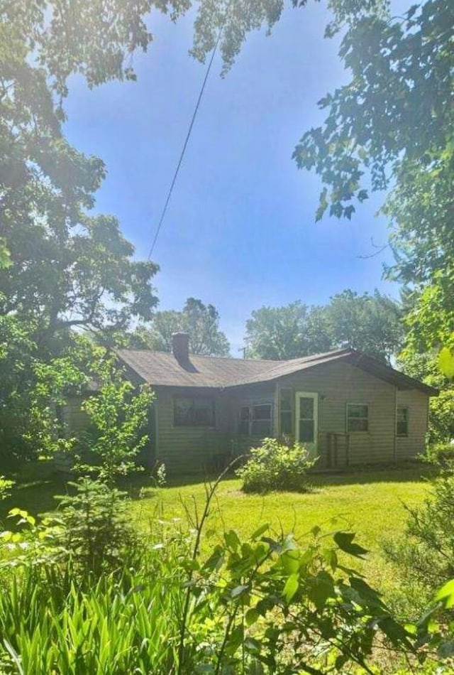 rear view of property with a lawn